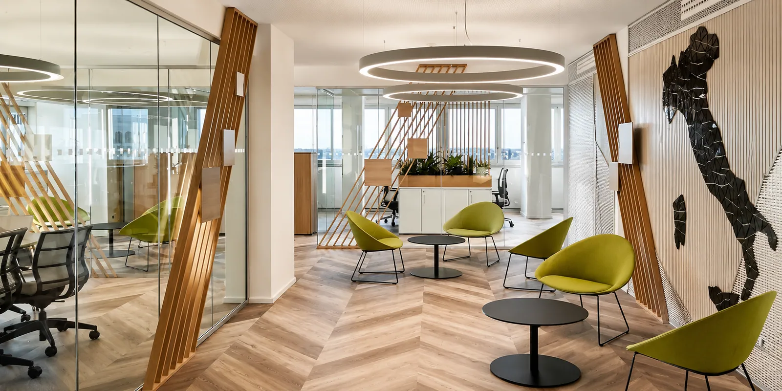 Area lounge con poltroncine gialle, partizioni in legno e pavimento a spina ungherese