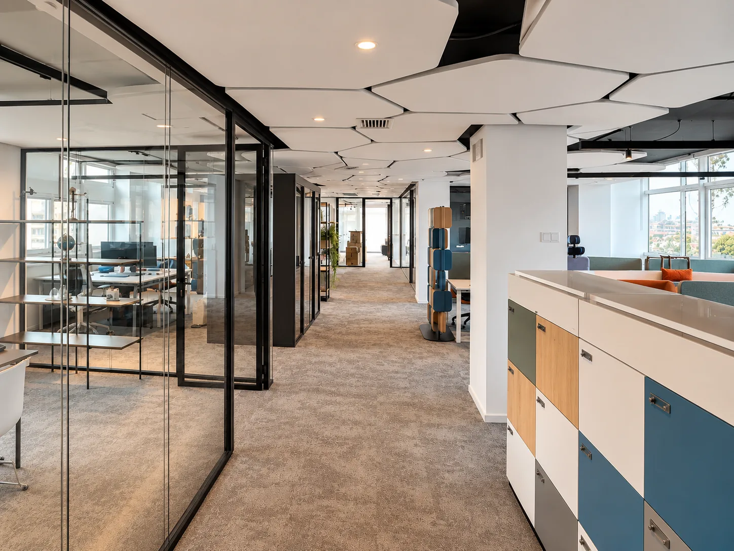 Open space del Workplace Lab con pareti vetrate, partizioni modulari colorate e controsoffitto acustico